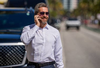 İş görüşmesi. Erkek telefon konuşması. Telefonu olan olgun bir İspanyol iş adamı. Girişimci zihniyeti işte. Müzakere çevrimiçi. İş adamı dışarıda telefonla konuşuyor. Telefon kullanan bir iş adamı.