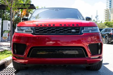 Miami, Florida, ABD - Nisan 06, 2025: 2019 Land Rover Range Sport HSE arabası. Lüks arazi aracı Range Rover. Otomobil Range Rover 'ı dışarıda park etmiş. Kırmızı SUV arabası, ön manzara..
