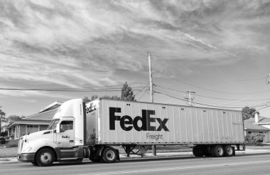 Chicago, ABD - 21 Ağustos 2024: Yolda FedEx konteynırlı kamyon. FedEx Şirketi, uluslararası kapsamı olan ABD merkezli bir lojistik şirketi. Federal Express teslimat işinde lider şirkettir..