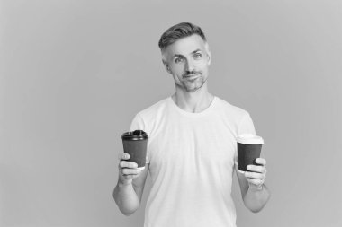 Olgun bir adam mavi üzerine kafeinsiz kahve fincanı seçer. Sabah kahvesi vakti. Yaşam tarzı konsepti. Kafeinsiz içiyorum. Çay içen adam. Sıcak bir sabah, rahatla. Kahveci adamla kahve molası. Reklam..