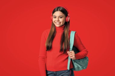 Genç kız sırt çantası taşıyor. Okula dönelim. Bilgi toplama günü. Eğitim kavramı. Kırmızıda izole edilmiş genç kız öğrenci. 1 Eylül. Lise eğitimi. Eearning yoluyla bilgi. Çevrimiçi çalışma.