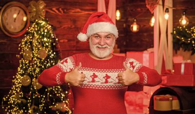 Geleneklere bağlı kal. Aralık indirimi. Noel Baba. Hediyelik eşya dükkanı. Yaşlı Noel Baba, İskandinav desenli süveter giyiyor. Kış gelenekleri. Yeni yılı kutlayalım. Şık, yaşlı bir adam. Noel gelenekleri.