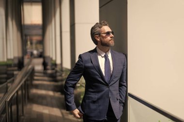 Yeni hedefler. İş vizyonu ve liderlik. Takım elbiseli bir iş adamı. Patron iş adamı. Girişimcinin başarısı. Ofis müdürü. İş yerindeki kendine güvenen iş adamı. Modern ofis binası.