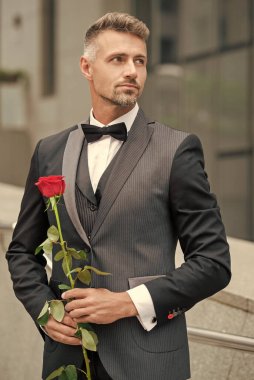 Siyah smokinli zarif adam. Smokin giymiş, papyonlu bir adam. Güllü yakışıklı smokinli adam..