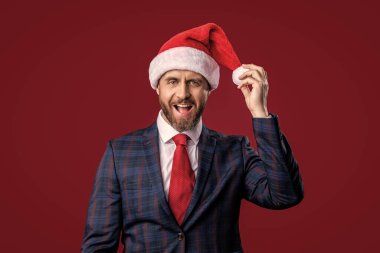 Şaşırmış Noel işadamı Noel Baba şapkası takıyor. İş adamı Noel Baba şapkası takıyor. Mutlu noeller. Noel Baba şapkalı işadamı kırmızıda izole edilmiş. Noel Baba iş adamının stüdyo fotoğrafı..