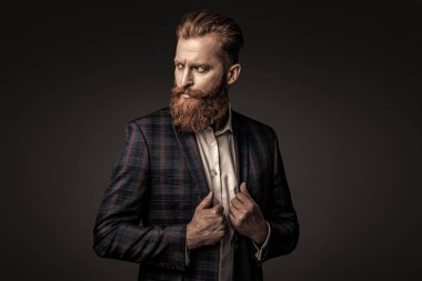 Zarif takım elbiseli hırslı bir adam. Erkekler için resmi moda. Erkek giyim modeli. Takım elbiseli şık bir adam. Sakallı bir iş adamı. Gri yolda yabani sakallı adam. Resmi giysi.