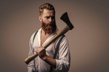 Erkeksi enerji. Retro tarzı. Yakışıklı ve karizmatik. Erkeksi adam. Baltası gri renkte olan sakallı bir adamın erkekliği. Sakallı ve bıyıklı, beyaz, vahşi bir adam. Moda saç stili.