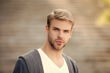Milenyum portresi. Genç milenyum adamı. Şık bir erkek portresi. Sıradan bir adam. Adamın şık saçları var. Moda görünümlü saçlı bir adam. Sıradan bir erkek portresi. Kesme biçimi.