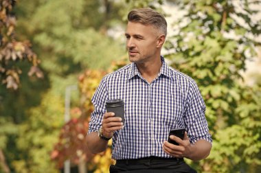 Dışarıdaki telefonda mesajlaşan bir adam. Kahve molasında iş mesajlaşması. Modern mobil iş iletişimi. İş adamı telefonda mesajlaşıyor. Telefonla konuşan bir adam. Telefon kullanımı.