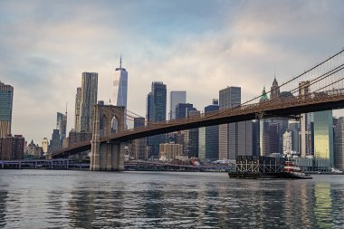 Brooklyn Köprüsü 'nün New York' taki gökdelenin üzerindeki manzarası inanılmaz. Brooklyn 'deki tarihi köprünün mimarisi. Manhattan 'a kadar. New York 'taki Brooklyn Köprüsü. Manhattan şehir manzarası. Mavna ve römorkör..