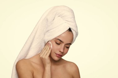 Güzellik rutini. Havluyla yüz temizleyen kadın derisi. Pamuk yumağıyla deriyi temizliyor. Cilt kozmetolojisi. Kaplıcada güzellik günü. Kadın pamuk pedi kullanıyor. Cilt bakımı. Makyajı sil. Yüz toneri.