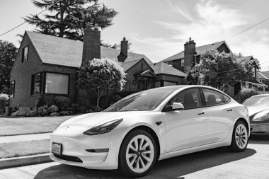 Seattle, WA, ABD - 3 Temmuz 2024: Tesla model 3 beyaz lüks evin yanında.