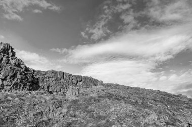 Rocky tektonik Almannagja dağı. Dağ jeolojisi kayası. Jeoloji kayalık uçurumu. Uçurumun kenarındaki Almannagja. İzlanda 'daki dağ uçurumu. İzlanda 'nın vahşi doğasında jeolojik tektonik kaya.