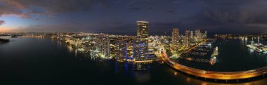 Miami silueti ve Biscayne Körfezi Panoraması. Kıyı gökdelenleri olan panoramik şehir manzarası. Miami Beach 'in yukarıdan manzarası. Drone Fisher Adası 'nı ve limanı ele geçirdi.