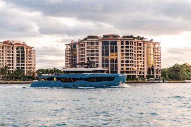 Marinaya yüzen bir tekne. Fisher Adası 'nda lüks bir yat teknesi. Yaz tatili. Fisher Adası konut binası ve lüks yat teknesi. Miami 'de Fisher Adası' na yat gezisi..