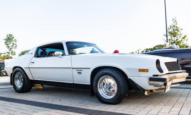 Park Ridge, Illinois, ABD - 21 Ağustos 2024: Otomobil fuarına park edilmiş beyaz araba, köşe manzaralı. Chevrolet Camaro 1976 eski araba. Chevrolet Camaro 'nun beyaz arabası. Chevy Camaro.