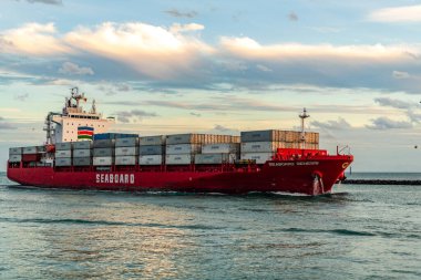 Miami, Florida, ABD - 3 Ocak 2025: Gündoğumunda konteyner gemisi. Kargo gemisi Seaboard Genesis ve konteynır Miami 'de. Yük konteynırı kargo gemisine yüklendi. Hava görüntülü kargo gemisi limana giriyor..