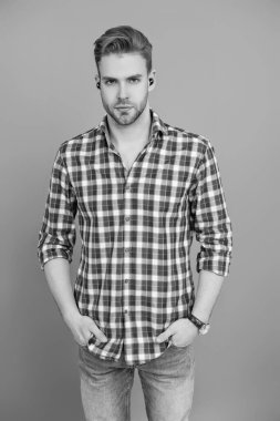 Kablosuz kulaklık cihazı. Aleti olan bir milenyum adamı. Kablosuz kulaklıklı bir adam. Adam gri üzerinde kulaklık kullanıyor. Modern kablosuz kulaklıklar. Elsiz kulaklık. Kulaklık cihazı aksesuarı. Kablosuz kulaklıklar..