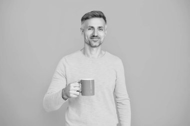 Sabah kahvesi vakti. Yaşam tarzı konsepti. Espresso içiyorum. Çay içen adam. Sıcak bir sabah. Evde kahve molası. Maviye izole edilmiş kahve fincanı olan olgun bir adam. Şerefe..