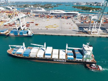 Miami, Florida, ABD - 20 Mart 2025: Kargo gemisi. Miami liman lojistiği. Monrovia konteynırı gemisi. Kargo Seaboard Explorer konteynır gemisi, hava manzaralı. Yük konteynırı kargo gemisi ve römorkör..