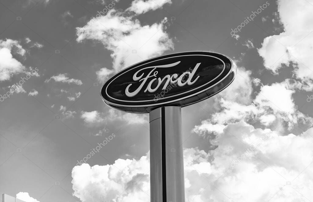 Chicago, USA - August 17, 2024: Ford logo sign against blue cloudy sky. Ford motor company is a oldest car company. Ford sign near dealership