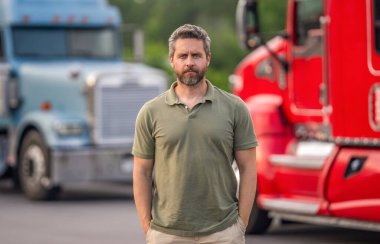 Kamyon kamyonunun yanında bir erkek kamyon şoförü. Nakliye araçları. Yarı kamyon aracı. İspanyol kamyoncu adam. Kamyonun önünde yakışıklı bir şoför. Kamyon sahibi. Kamyon şoförü. LGV sürücüsü.