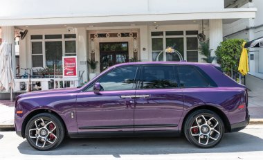 Miami, Florida, ABD - 19 Nisan 2025 Rolls Royce Cullinan SUV arabası. Lüks SUV Rolls Royce Cullinan. Araba Rolls Royce Cullinan dışarı park etmiş. Mor araba, yan görüş..