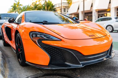 Miami, Florida, ABD - 07 Nisan 2025: Turuncu spor yara izi, ön manzara. McLaren 650S 2015 spor araba. Lüks spor araba McLaren 650S. Araba McLaren 650S dışarıda park halinde..