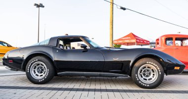 Park Ridge, Illinois, ABD - 18 Ağustos 2024: Corvette c3 stingray. Otomobil fuarında park edilmiş siyah bir araba. Corvette c3 vatozlu araba. Siyah Corvette C3 vatozlu araba