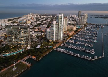Miami marinasındaki lüks yatların hava manzarası. Miami marinasındaki tekne ve gökdelenlerin manzarası. Miami kıyı şeridi boyunca yelken açan yat.