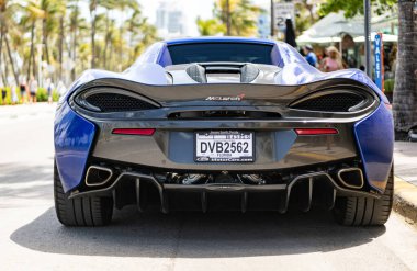 Miami, Florida, USA - April 19, 2025: Car McLaren 570S parked outdoor. Blue sportscar, rear view. 2018 McLaren 570S sportscar car. Luxury sport car McLaren 570S.