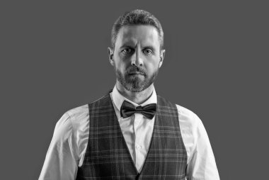 Garson. Smokinli erkek giysili adam Griler 'de izole edilmiş. Resmi erkek giyim sektöründe karizmatik bir adam. Yakışıklı garson adam smokin giyer. Şık smokin papyonu. Papyonlu garson servis yapmaya hazır..