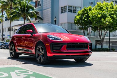 Miami, Florida, ABD - 06 Nisan 2025: Porsche Macan açık havada park etti. Kırmızı araba, yan görüş. Porsche Macan 2025 geçiş aracı. Lüks araba Porsche Macan..