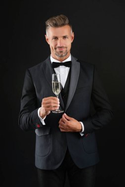 - Şerefe. Resmi etkinlikte smokin giyen adam. Şampanyayla kutlayın. Kutlama ve tezahürat. Düğün smokinli adam. Şık smokinli adam siyah üzerine izole edilmiş şampanya bardağı tutuyor. Başarı kutlaması.