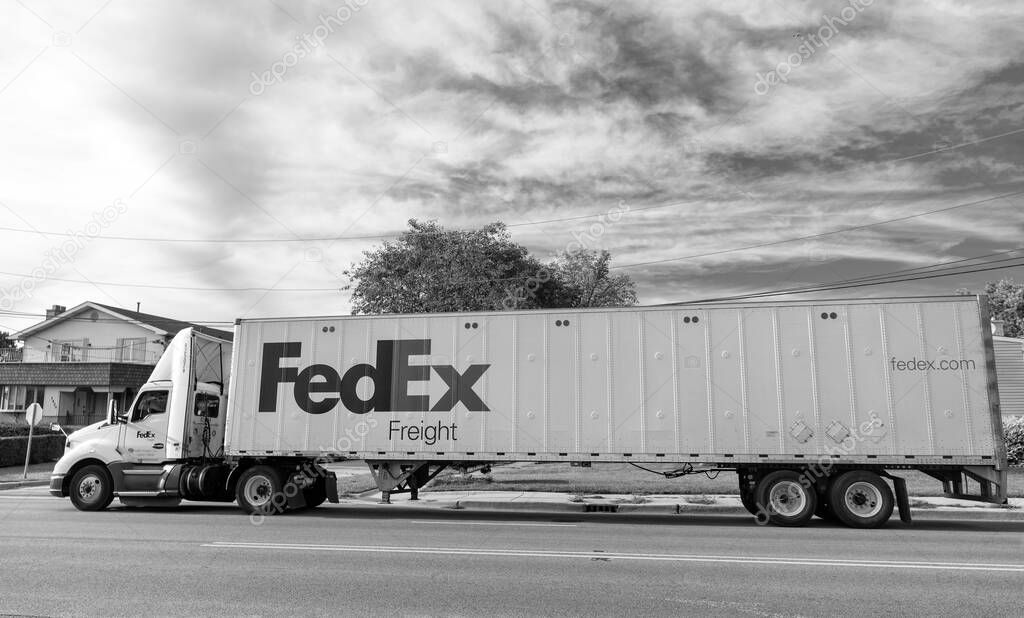 Chicago, USA - August 21, 2024: Truck with FedEx container on truck on the road. FedEx Corporation, a U.S.-based logistics company with international coverage. Federal Express is leader company in the delivery business.