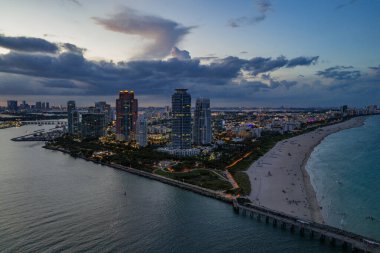Miami sahil şeridinin hava gece görüşü. Miami Okyanusu 'nun üzerindeki alacakaranlık silueti. Miami Sahili Sahili dramatik gökyüzü
