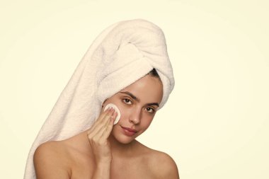 Cilt bakımı. Makyajı sil. Güzellik rutini. Havluyla yüz temizleyen kadın derisi. Pamuk yumağıyla deriyi temizliyor. Cilt kozmetolojisi. Kaplıcada güzellik günü. Kadın pamuk pedi kullanıyor. Temizleme rejimi.