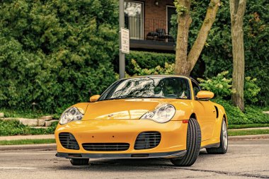 Chicago, Illinois - 29 Eylül 2024: Porsche 911 Turbo Carrera S sarı renk. Porsche 911 turbo Carrera S yolda. ön görünüm