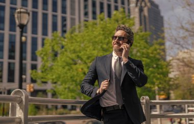 İş iletişimi. İş adamının dışarıyı araması gerekiyor. Telefon kullanan bir iş adamı. İletişim kanalları. Takım elbiseli bir adam telefonda konuşuyor. Telefonu olan orta yaşlı İspanyol işadamı..