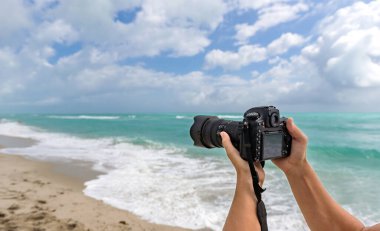Sahildeki fotoğraf makinesi. Yaz tatili. Seyahat ve fotoğrafçılık. Fotoğraf makinesi, fotoğraf makinesi, fotokopi makinesi. Yaz plajında kameralı bir gezgin. Seyahat fotoğrafçılığı. Yazın seyahat..