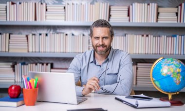 Okulda öğretmenle çevrimiçi eğitim almak sınıfta dizüstü bilgisayarla..