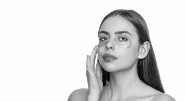 Kadının gözlerinin altında kolajen bantları olan taze ve sağlıklı bir cildi var. Yüz bakımı. Göz bandı takan bir kadın. Spa bakımı. Göz bandı. Göz altlarında kolajen pedleri olan güzel kadın yüzü. Siyah halkalarla savaş.