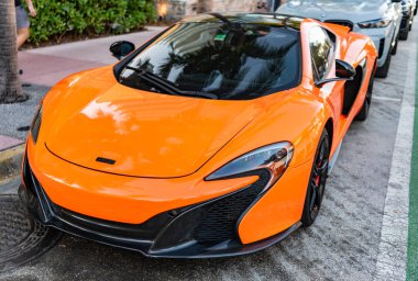 Miami, Florida, ABD - 07 Nisan 2025: Turuncu spor yara izi, ön manzara. McLaren 650S 2015 spor araba. Lüks spor araba McLaren 650S. Araba McLaren 650S dışarıda park halinde..
