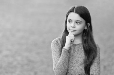 Tam bir kıyafet tarzı. Sıradan süveter giyen bir kız. Uzun, sağlıklı saçlar. Genç kızın açık havada uzun saçları var. Sonbahar moda kızı. Modaya uygun ergen kız düşüncesi. Gençler için sonbahar moda tarzı.