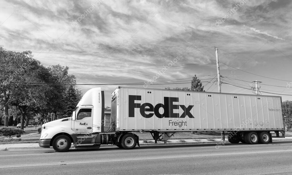 Chicago, USA - August 21, 2024: Truck with FedEx container on truck on the road. FedEx Corporation, a U.S.-based logistics company with international coverage. Federal Express is leader company in the delivery business.