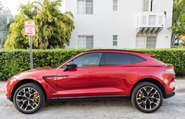 Miami, Florida, ABD - 17 Nisan 2025 Lüks araç Aston Martin DBX. Araba Aston Martin DBX dışarı park edilmiş. Kırmızı araba, yan görüş. Aston Martin DBX 2021 geçiş aracı.