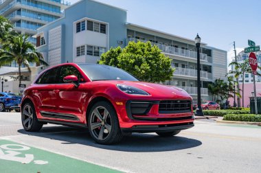 Miami, Florida, ABD - 06 Nisan 2025: Porsche Macan açık havada park etti. Kırmızı araba, yan görüş. Porsche Macan 2025 geçiş aracı. Lüks araba Porsche Macan..
