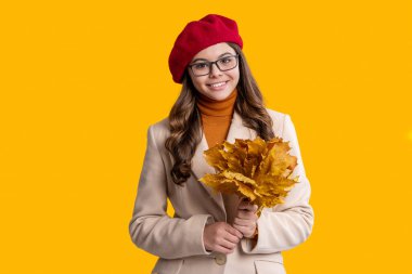 Sonbahar bereli genç kız. Sonbahar yaprakları. Sonbahar tarzı bir kız. Sonbahar modası. Sonbahar yaprakları elinde genç kız. Sonbahar yaprakları ve genç kız sarıda izole edilmiş..