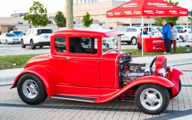 Park Ridge, Illinois, ABD - 22 Ağustos 2024: Ford model 1927 üstü açılır araba. Ford A modelinin klasik arabası. Klasik Ford A model açık hava modeli. Kırmızı Retro araba otomobil fuarında park edilmiş, köşe manzaralı..
