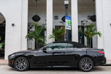 Miami, Florida, ABD - 2 Nisan 2025: BMW 4 serisi 2022 üstü açılabilir coupe araba. Üstü açık lüks BMW 4. Üstü açık BMW 4 arabası dışarıda park edilmiş. Siyah üstü açık araba, köşe manzaralı..